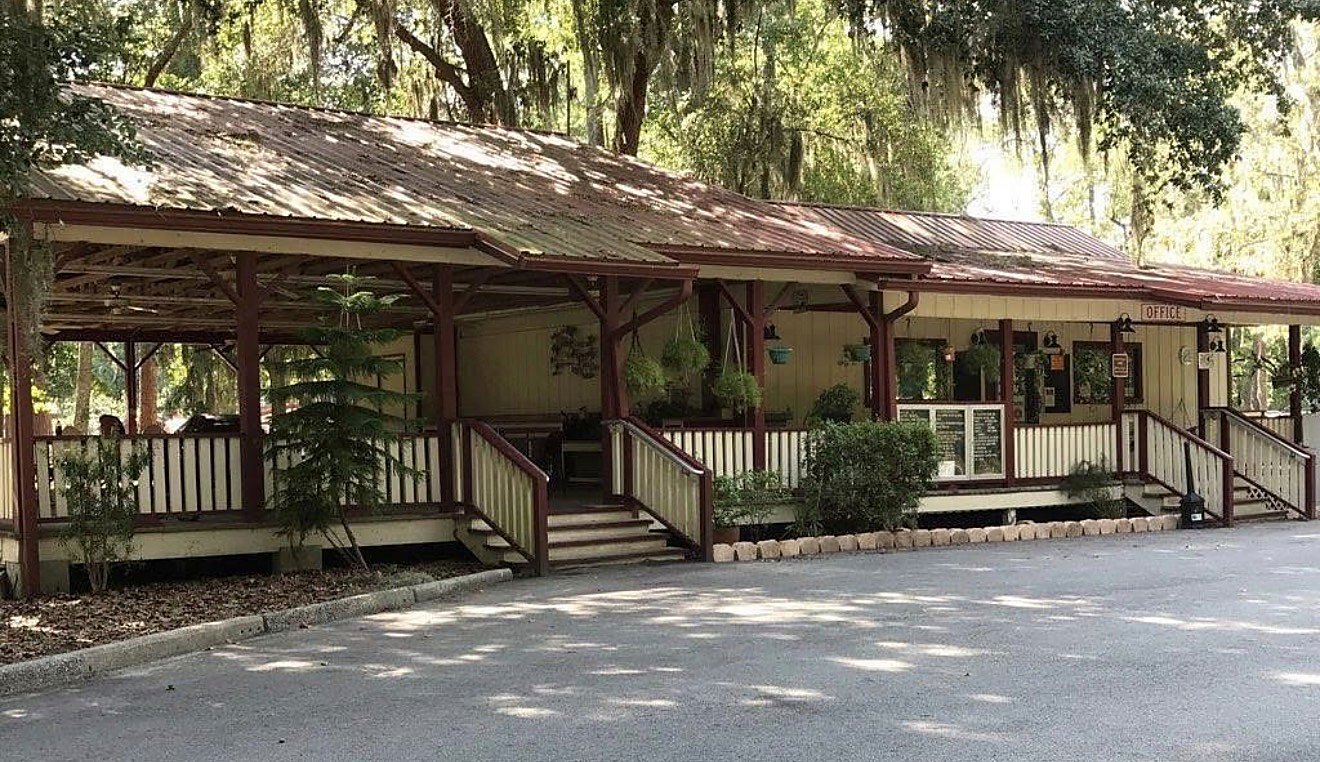 The wood-framed campground office and check-in building at Blythe Island Regional Park in Brunswick, Georgia, shaded by live oaks draped in Spanish moss.